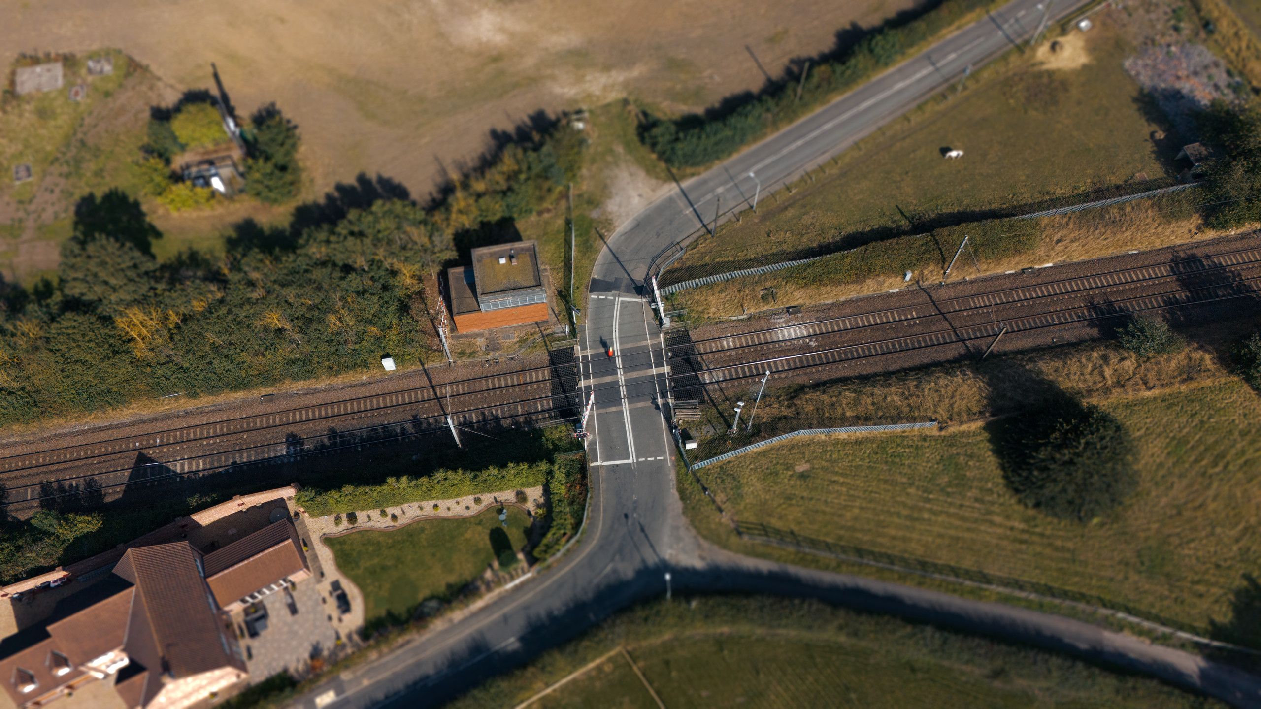 Top-down aerial photograph of a road crossing several railway lines