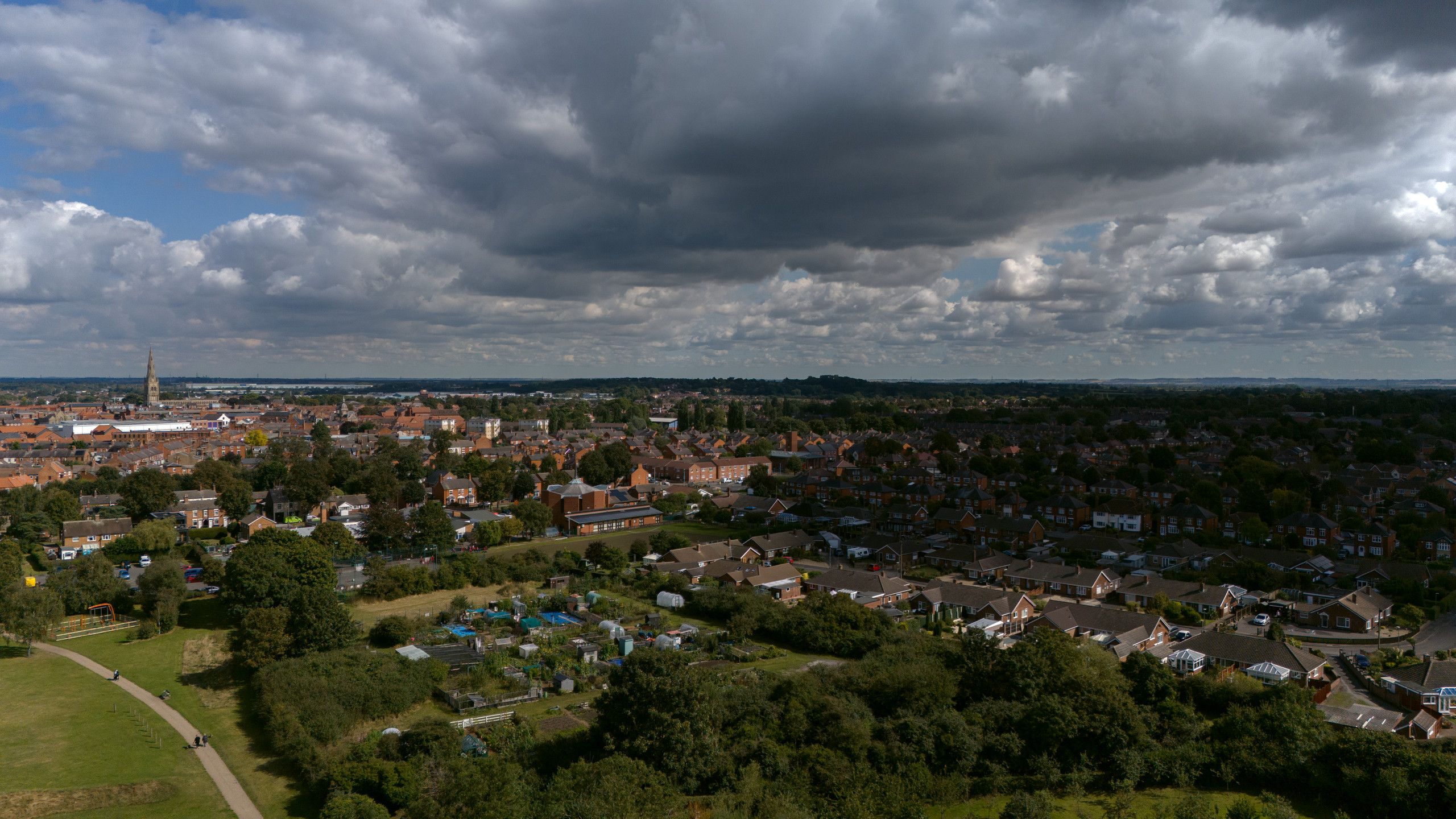 Aerial view of a town beneath a large bank of dark cloud
